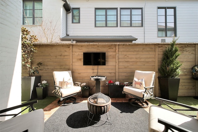 view of patio / terrace with a fire pit and fence