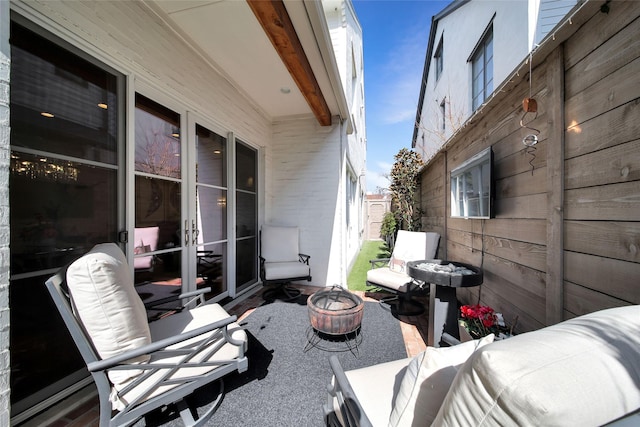 view of patio / terrace with french doors, fence, and an outdoor fire pit