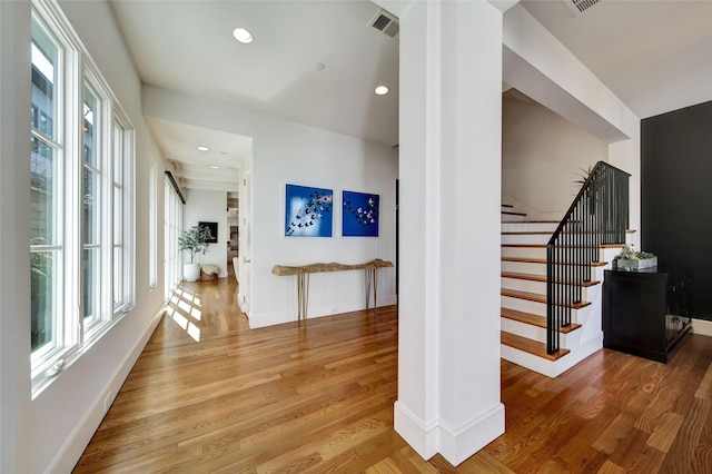 corridor with visible vents, baseboards, stairs, recessed lighting, and wood finished floors