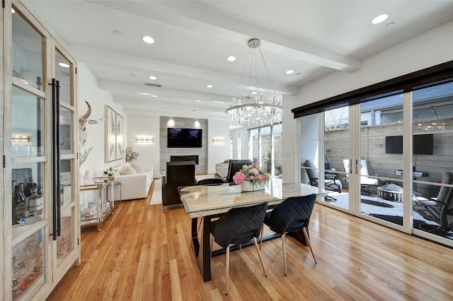 dining area with light wood-type flooring, beamed ceiling, visible vents, recessed lighting, and a large fireplace