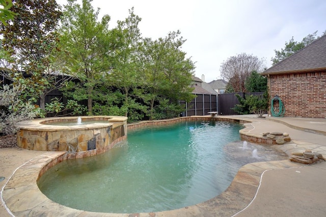 view of pool with a fenced backyard and a pool with connected hot tub