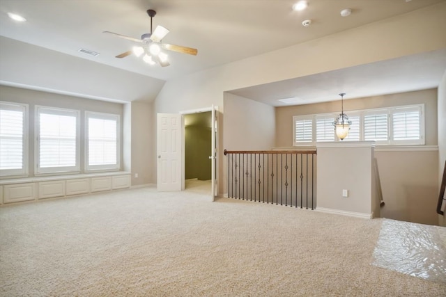 empty room with lofted ceiling, carpet flooring, baseboards, and visible vents