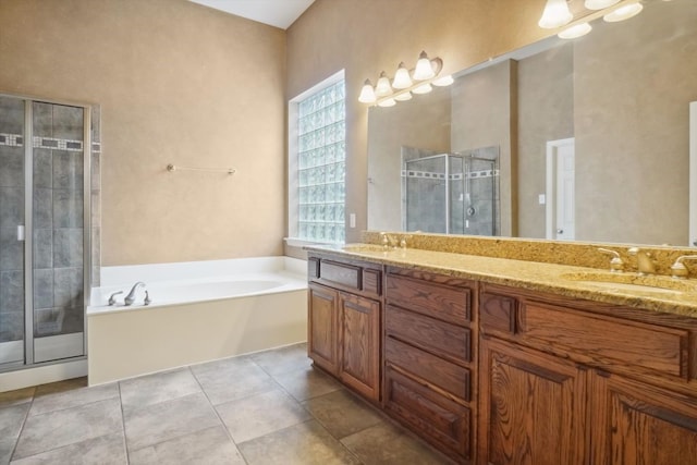 full bathroom with double vanity, a sink, a shower stall, a garden tub, and tile patterned floors