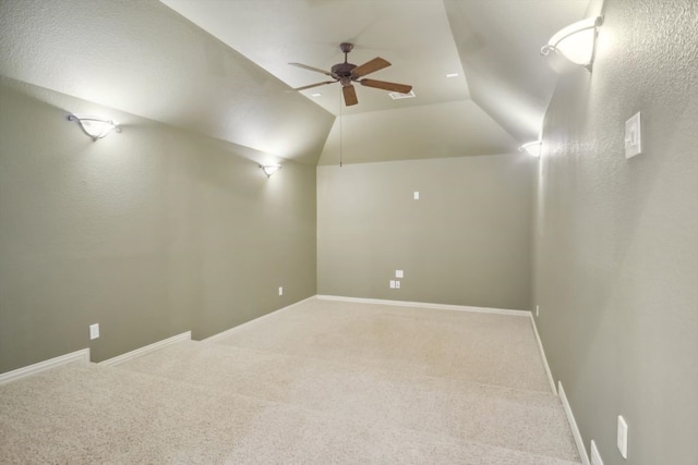 unfurnished room featuring lofted ceiling, baseboards, carpet floors, and ceiling fan