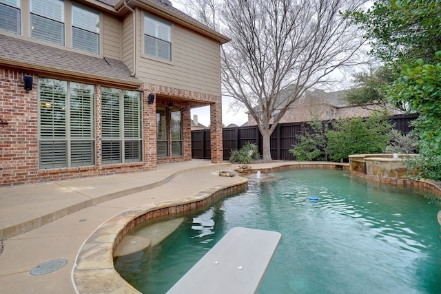 view of pool featuring a diving board, a fenced in pool, and a fenced backyard