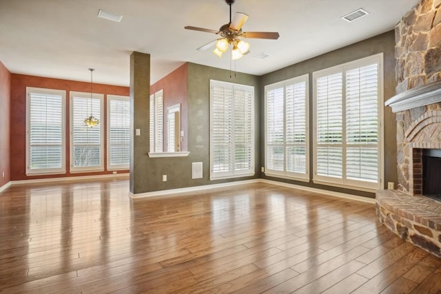 unfurnished living room featuring plenty of natural light, a fireplace, and wood finished floors