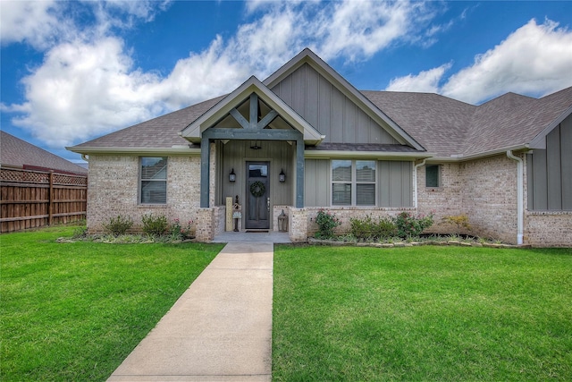 view of front of home with a front lawn, fence, board and batten siding, and a shingled roof