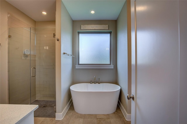 bathroom featuring baseboards, a freestanding bath, vanity, and a shower stall