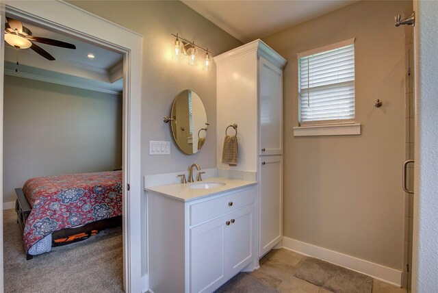 ensuite bathroom with baseboards, vanity, ceiling fan, and crown molding