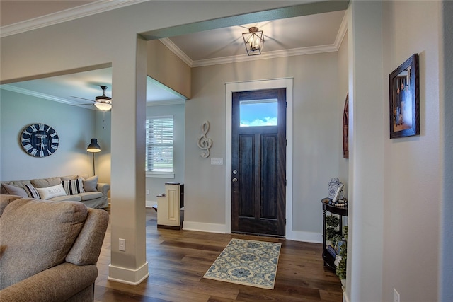 foyer with ceiling fan, dark wood-type flooring, baseboards, and ornamental molding