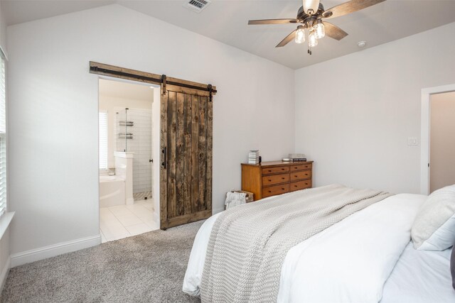 bedroom with visible vents, ensuite bath, a barn door, carpet flooring, and lofted ceiling