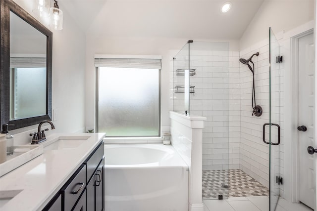 full bath with double vanity, lofted ceiling, a sink, a shower stall, and a garden tub