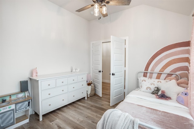 bedroom featuring a ceiling fan, light wood-type flooring, and lofted ceiling