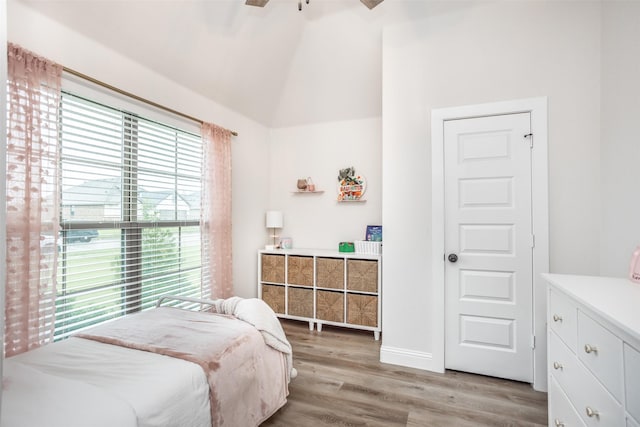 bedroom featuring ceiling fan, baseboards, light wood-style flooring, and vaulted ceiling