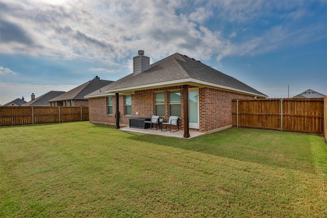 rear view of house featuring brick siding, a fenced backyard, a lawn, and a patio area