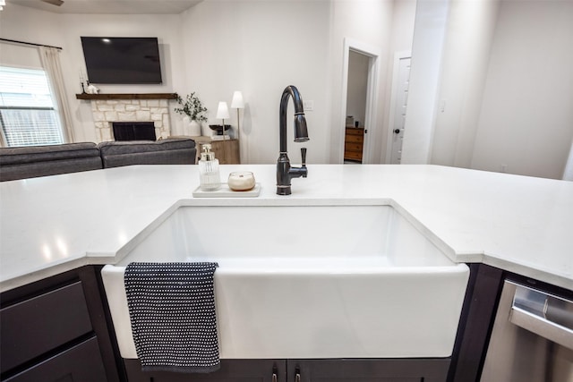 room details featuring a fireplace, dishwasher, and a sink