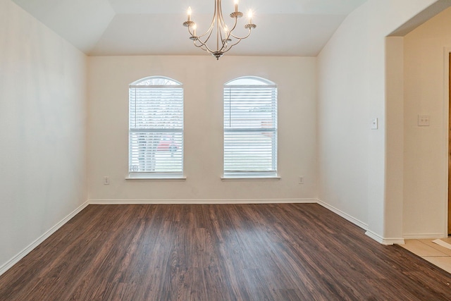 unfurnished room featuring lofted ceiling, dark wood-style floors, baseboards, and a chandelier