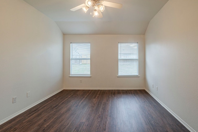 spare room featuring baseboards, dark wood-type flooring, ceiling fan, and vaulted ceiling