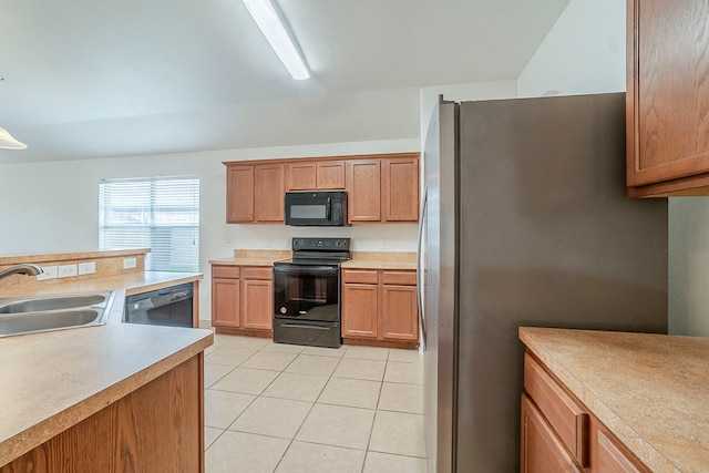 kitchen with black appliances, light tile patterned floors, light countertops, and a sink