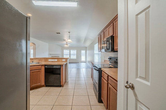 kitchen with light tile patterned floors, black appliances, brown cabinetry, and light countertops