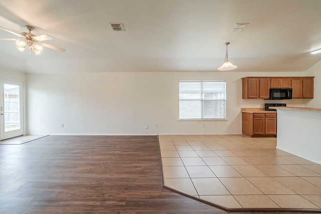 kitchen with open floor plan, visible vents, and black microwave