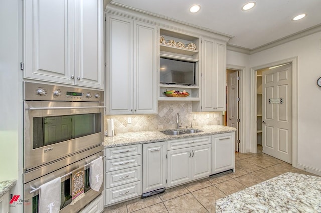 kitchen featuring white cabinetry, open shelves, stainless steel double oven, and a sink