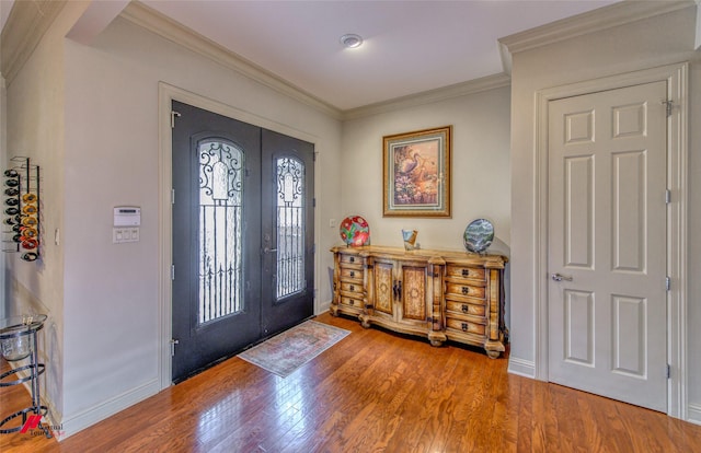 foyer with french doors, wood finished floors, baseboards, and ornamental molding