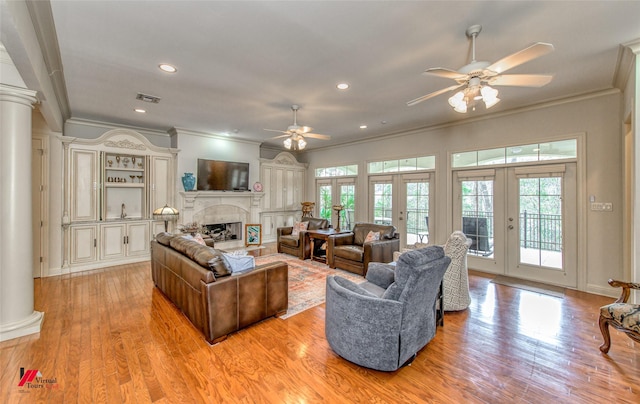 living area with a wealth of natural light, french doors, visible vents, and decorative columns