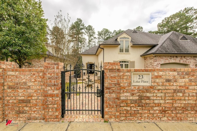 view of gate with a fenced front yard