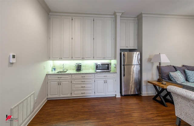 kitchen with dark wood-style floors, visible vents, a sink, appliances with stainless steel finishes, and white cabinetry