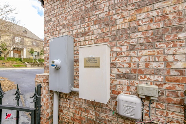 exterior details featuring brick siding and electric meter