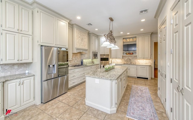 kitchen with a sink, stainless steel appliances, a kitchen island, and visible vents