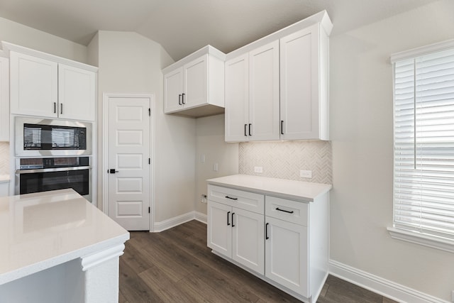 kitchen featuring dark wood-style floors, decorative backsplash, white cabinets, and appliances with stainless steel finishes