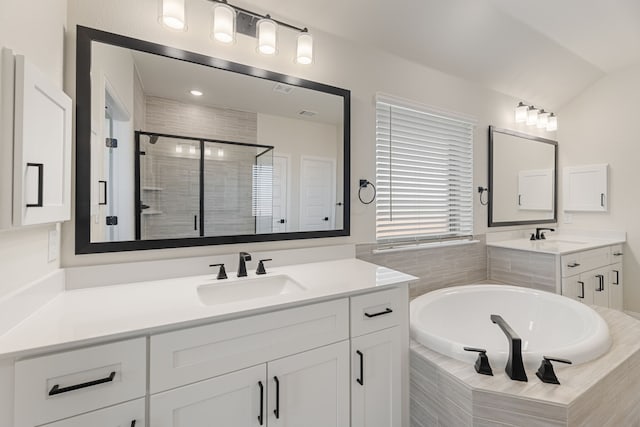 full bathroom featuring a garden tub, two vanities, a shower stall, and a sink