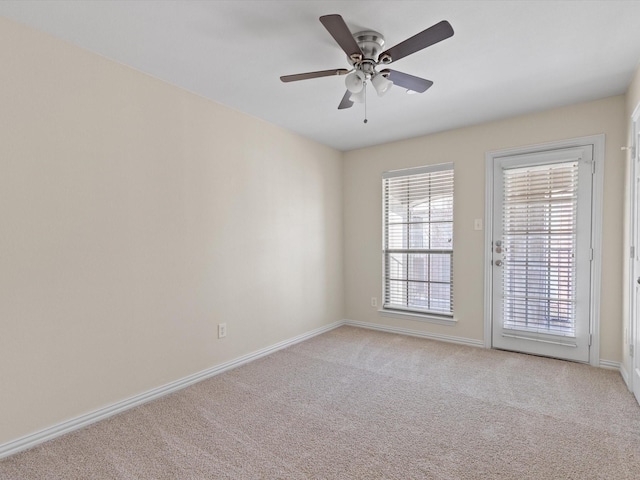 unfurnished room featuring light colored carpet, baseboards, and ceiling fan