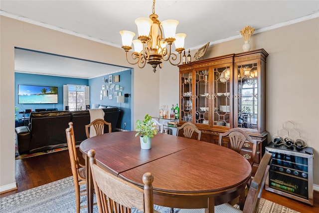 dining space with baseboards, a notable chandelier, wood finished floors, and ornamental molding