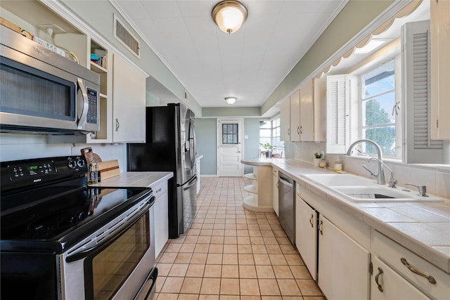 kitchen featuring tile countertops, visible vents, appliances with stainless steel finishes, and a sink