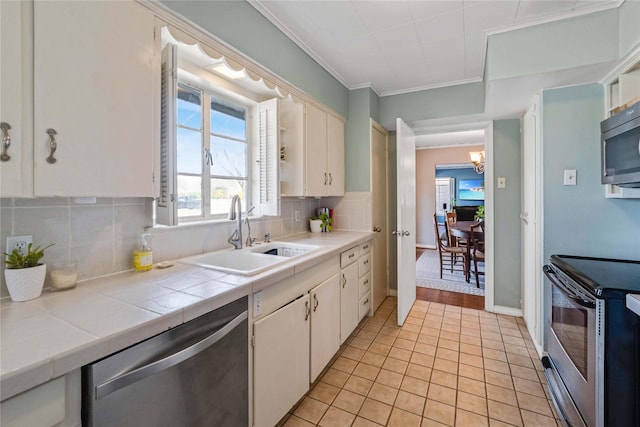 kitchen with a sink, backsplash, tile countertops, stainless steel appliances, and light tile patterned floors