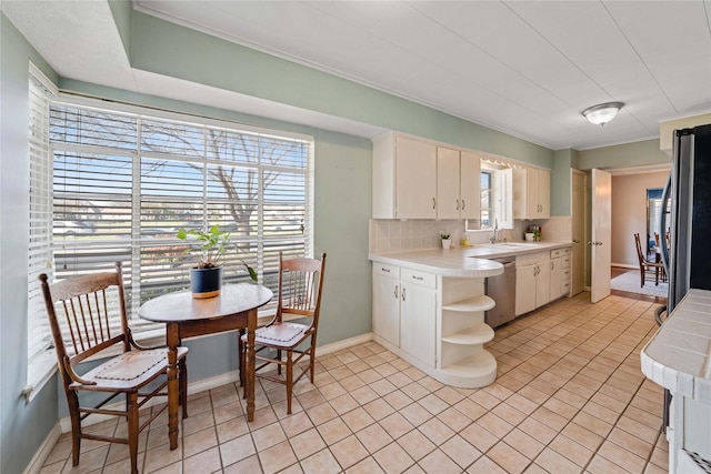 kitchen with backsplash, open shelves, baseboards, appliances with stainless steel finishes, and a sink