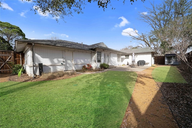 back of property featuring fence, a lawn, and a patio area