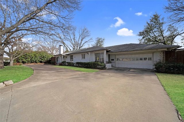 ranch-style house featuring concrete driveway, a garage, a front yard, and a chimney