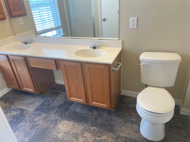 full bathroom with a sink, toilet, and double vanity