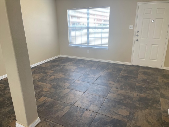 entryway featuring stone finish floor and baseboards