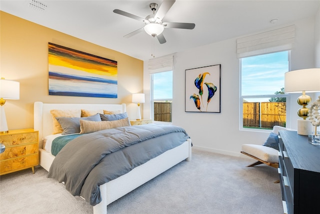 carpeted bedroom featuring baseboards, visible vents, and ceiling fan