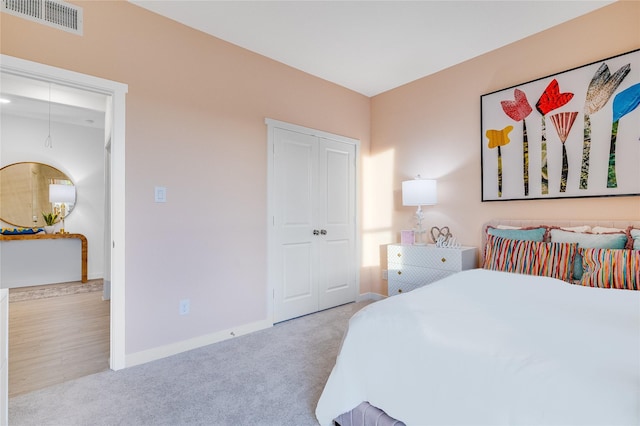 bedroom with visible vents, baseboards, carpet, and a closet