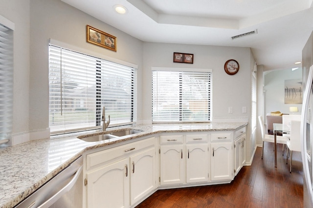 kitchen featuring visible vents, a sink, white cabinets, a raised ceiling, and dishwasher