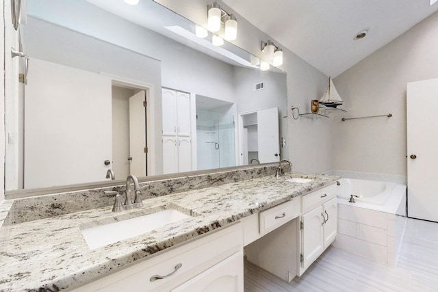 full bath featuring lofted ceiling, a garden tub, a stall shower, and a sink