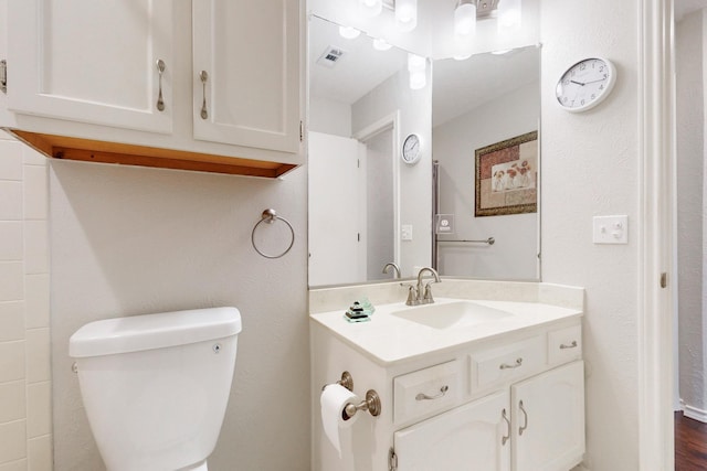 bathroom featuring visible vents, toilet, and vanity