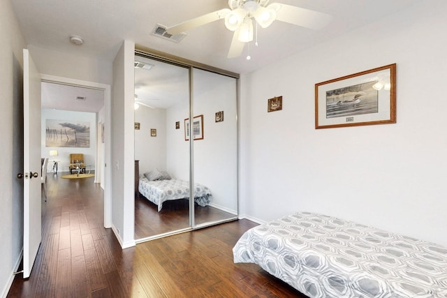 bedroom featuring visible vents, baseboards, a closet, a ceiling fan, and dark wood-style flooring