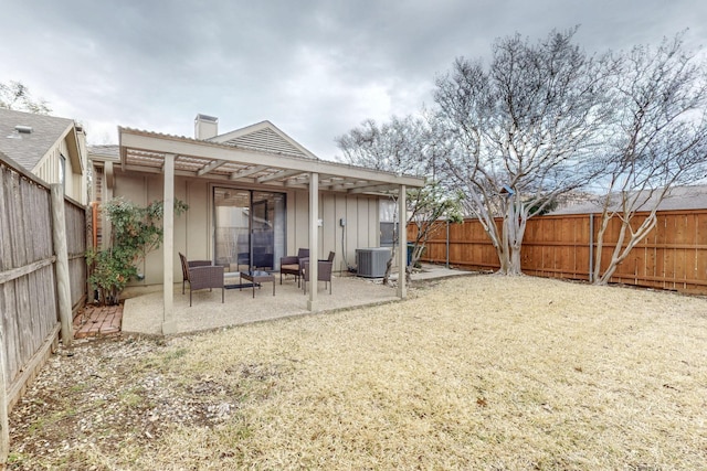 rear view of property with a patio, a fenced backyard, and a chimney